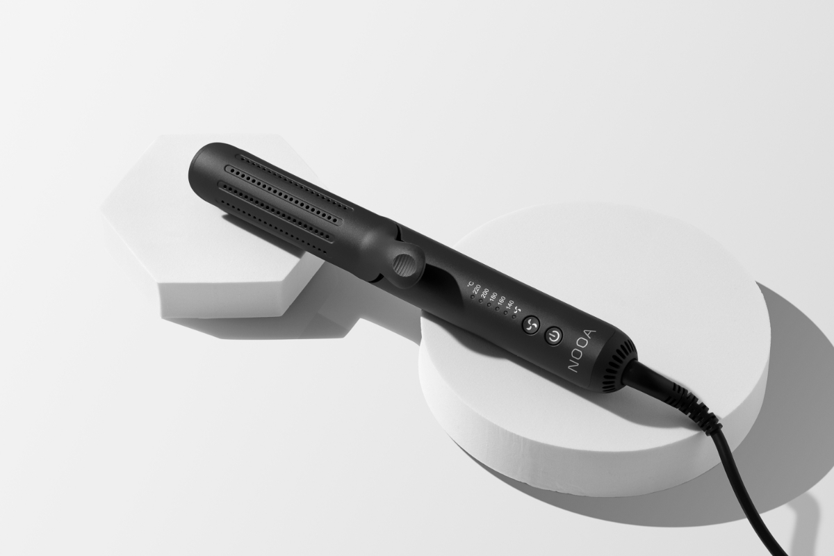 Wide angle image of NOOA GEMINI CURLER & STRAIGHTENER propped up on two white boxes