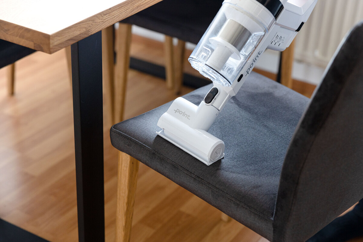 Point stick vacuum cleaner's handheld vacuum vacuumin a chair in the living room