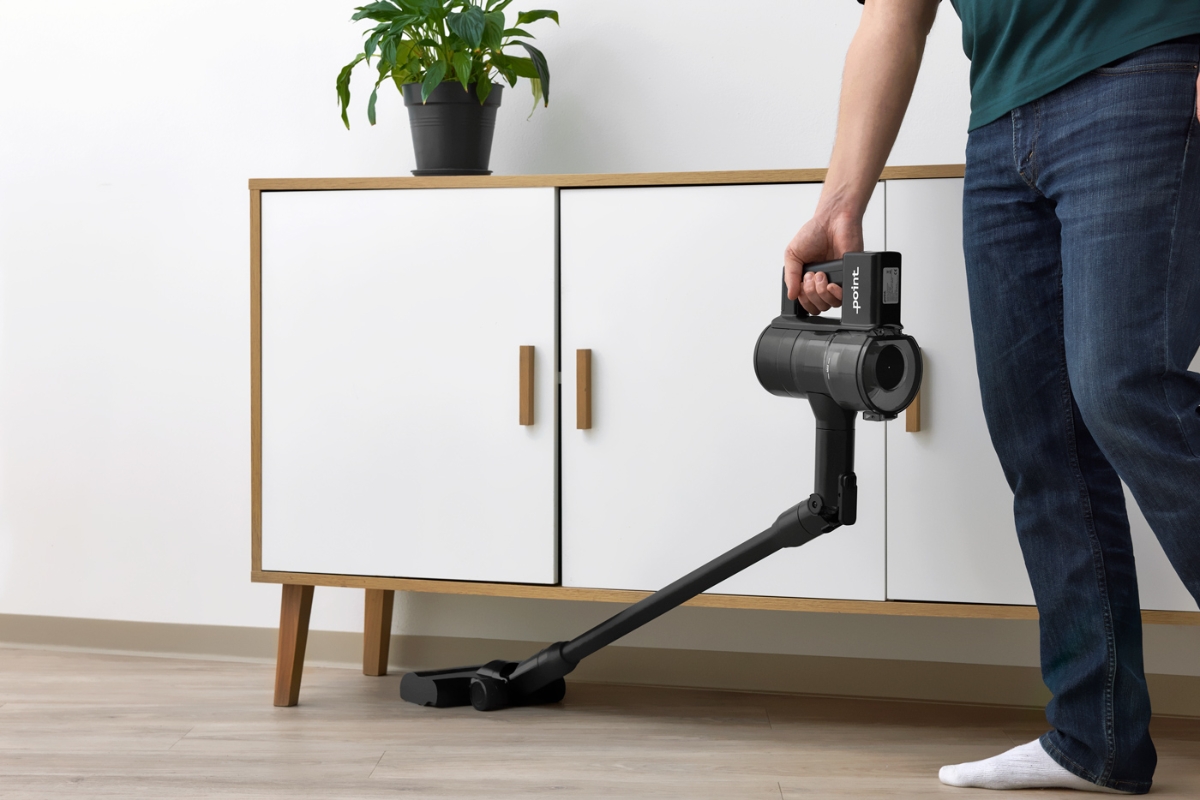 POINT PENCIL+ CORDLESS VACUUM CLEANER bent to a 90° angle, vacuuming under a white side table