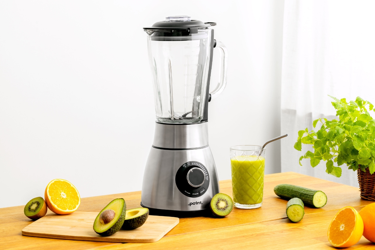 Wide angle image of POINT PRO POBLYBS13 POWER BLENDER empty, with cut fruit next to it on wooden kitchen counter