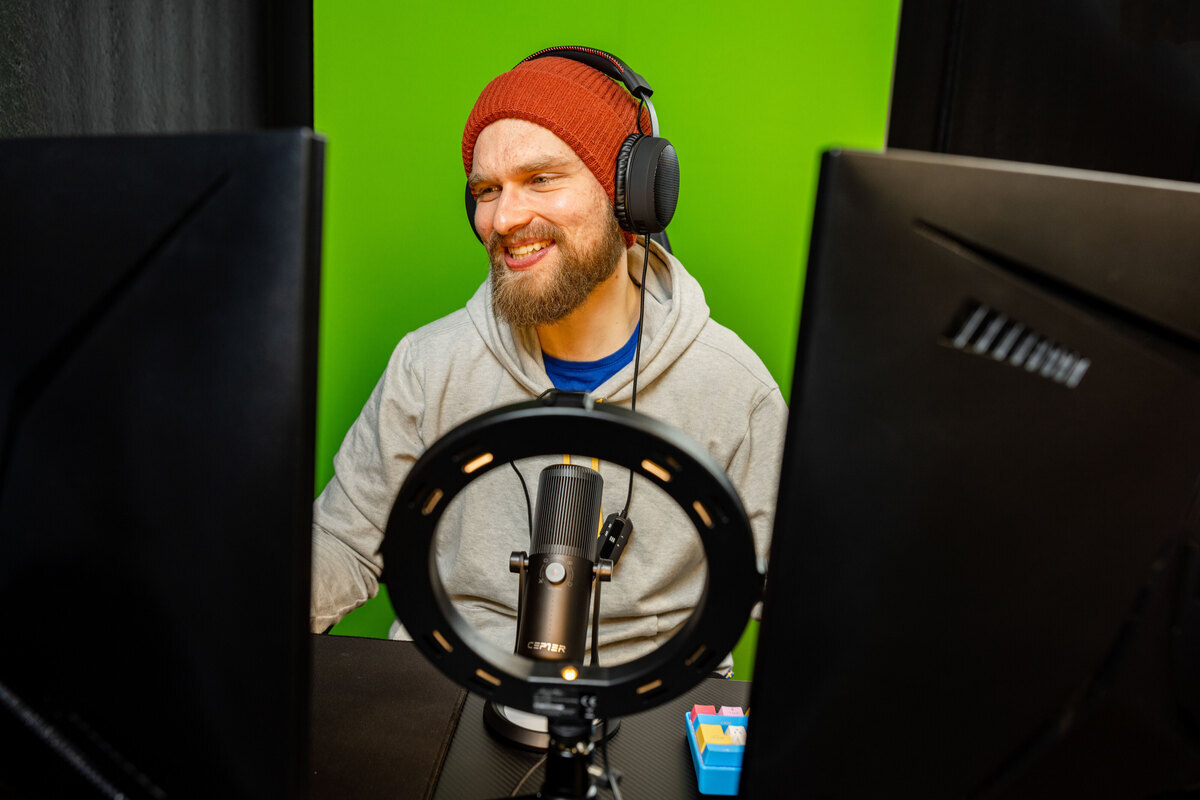 Person in a streaming setup in front of a green screen