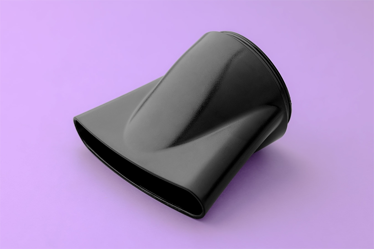 A black colored concentrator for Point Retract hair dryer against a purple background