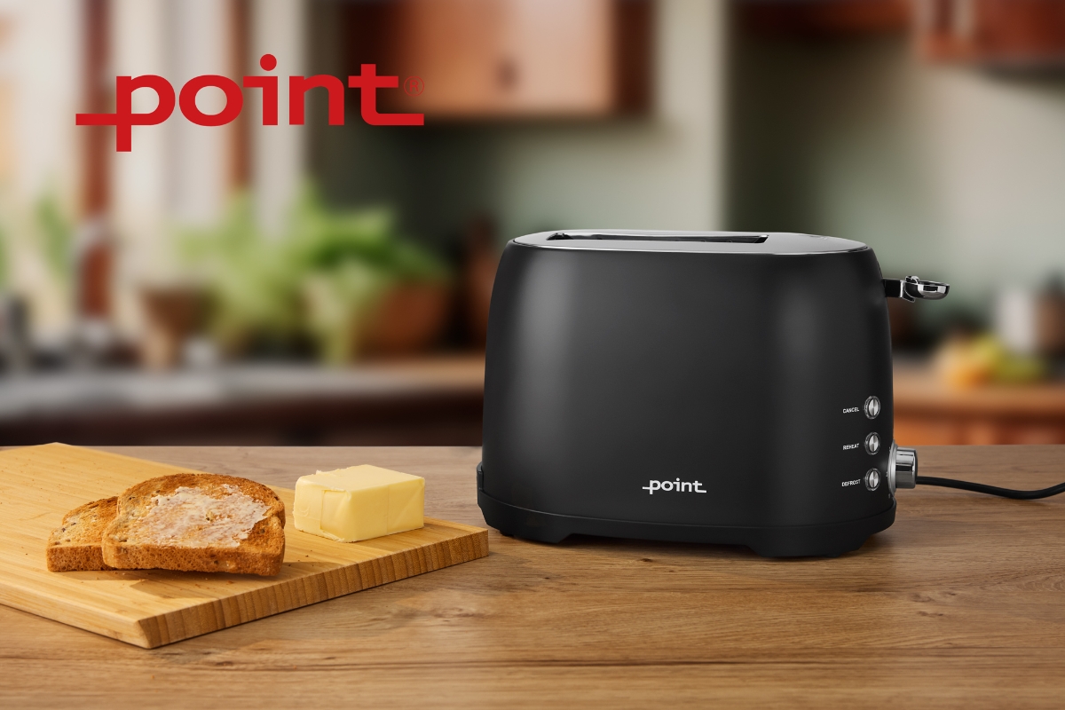Wide angle image of POINT POT5020BK RETRO TOASTER BK/2 SLOTS on a wooden countertop, with a slice of bread and knob of butter next to it