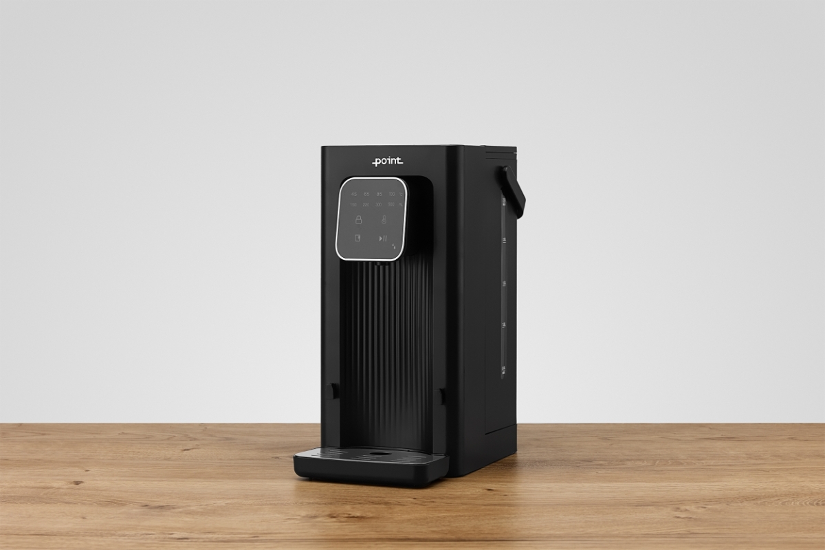 POINT POWD5000 INSTANT HOT WATER DISPENS A black Point hot water dispenser on a wooden table with a light grey background and the machine tilted a bit to the left