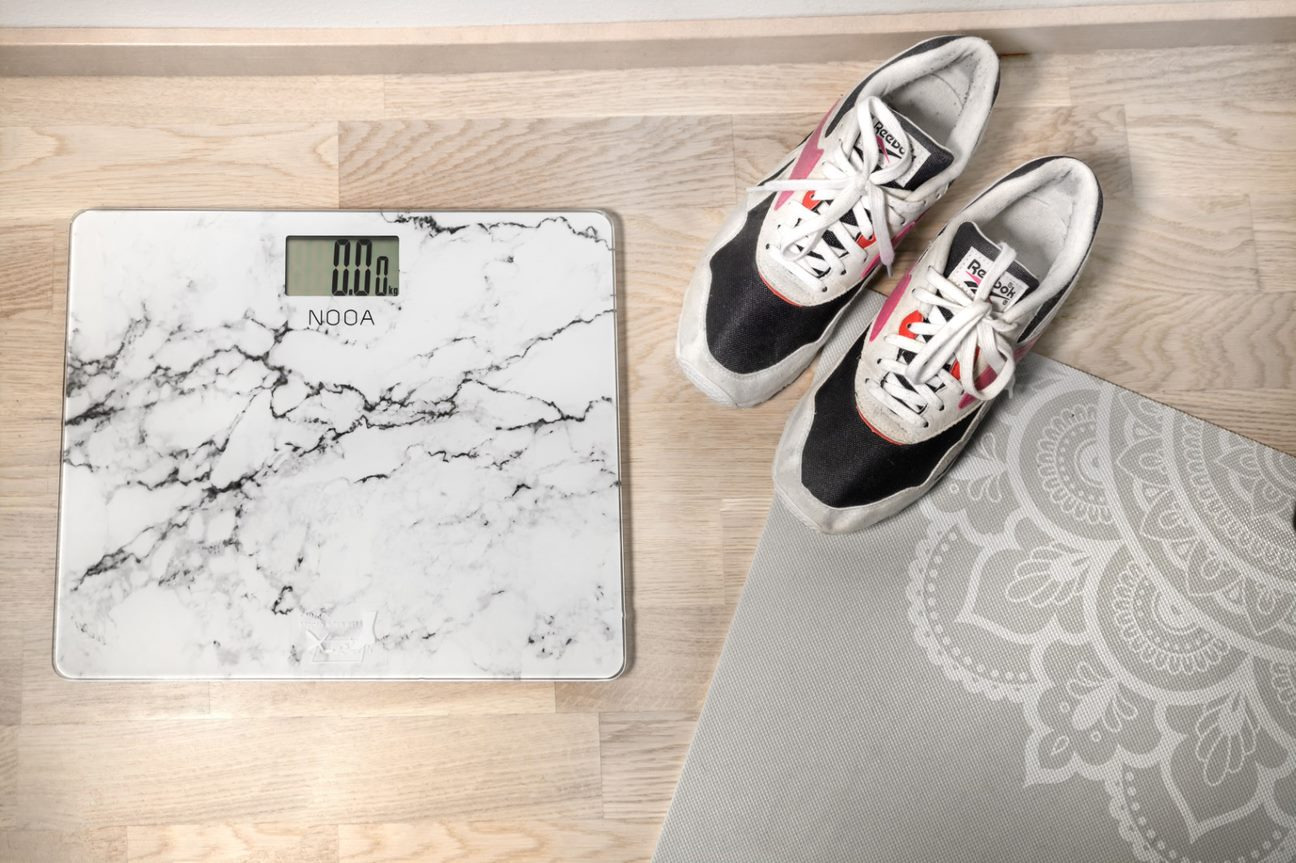 Nooa personal scale next to a carpet and trainers