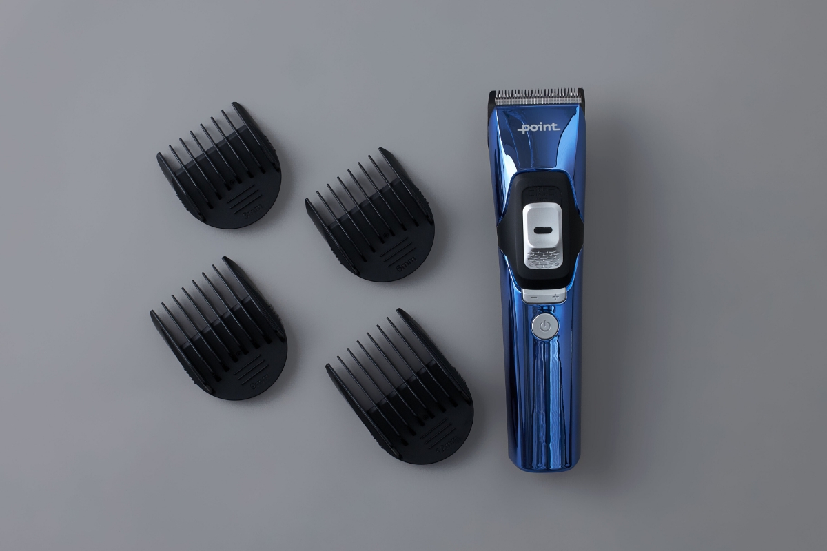 Wide angle image of POINT TRIM TECH BEARD TRIMMER and its guide combs against dark grey background