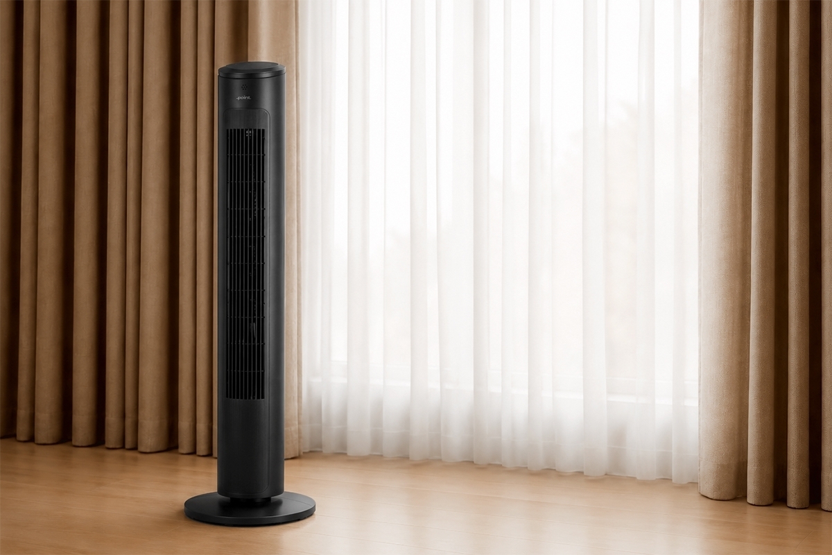 Black Point tower fan on a wooden floor in a room with lots of light and a window next to the fan that has white curtains