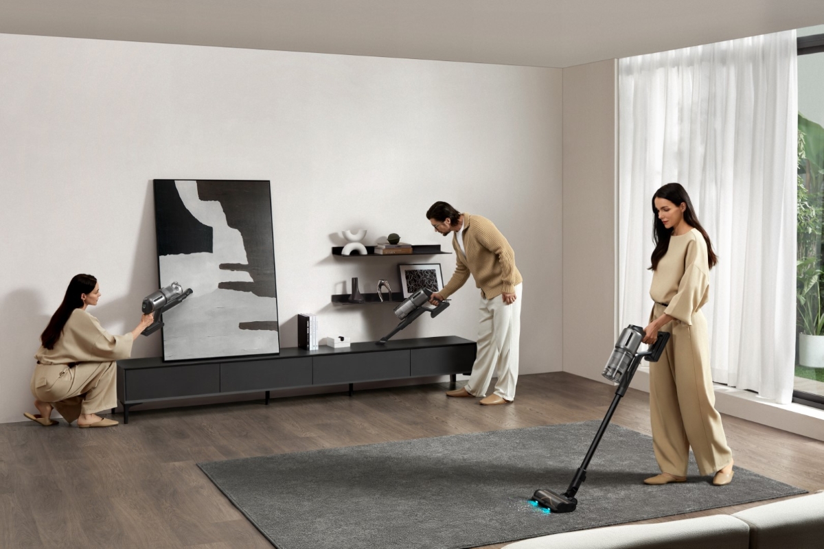 Wide angle image of a person using the DREAME Z30 STICK VACUUM CLEANER in a living room for different cleaning purposes, illustrating the versatility of the stick vacuum