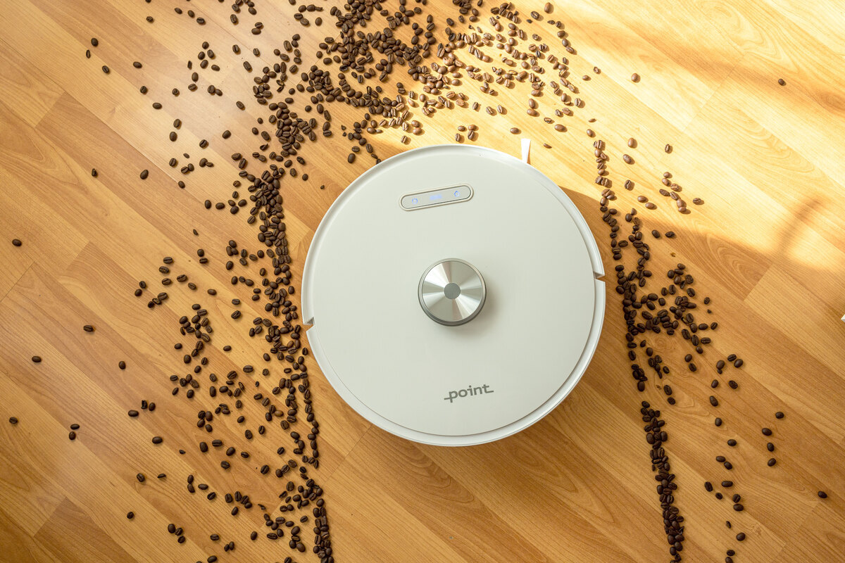 Robot vacuum vacuuming the coffee beans on the floor