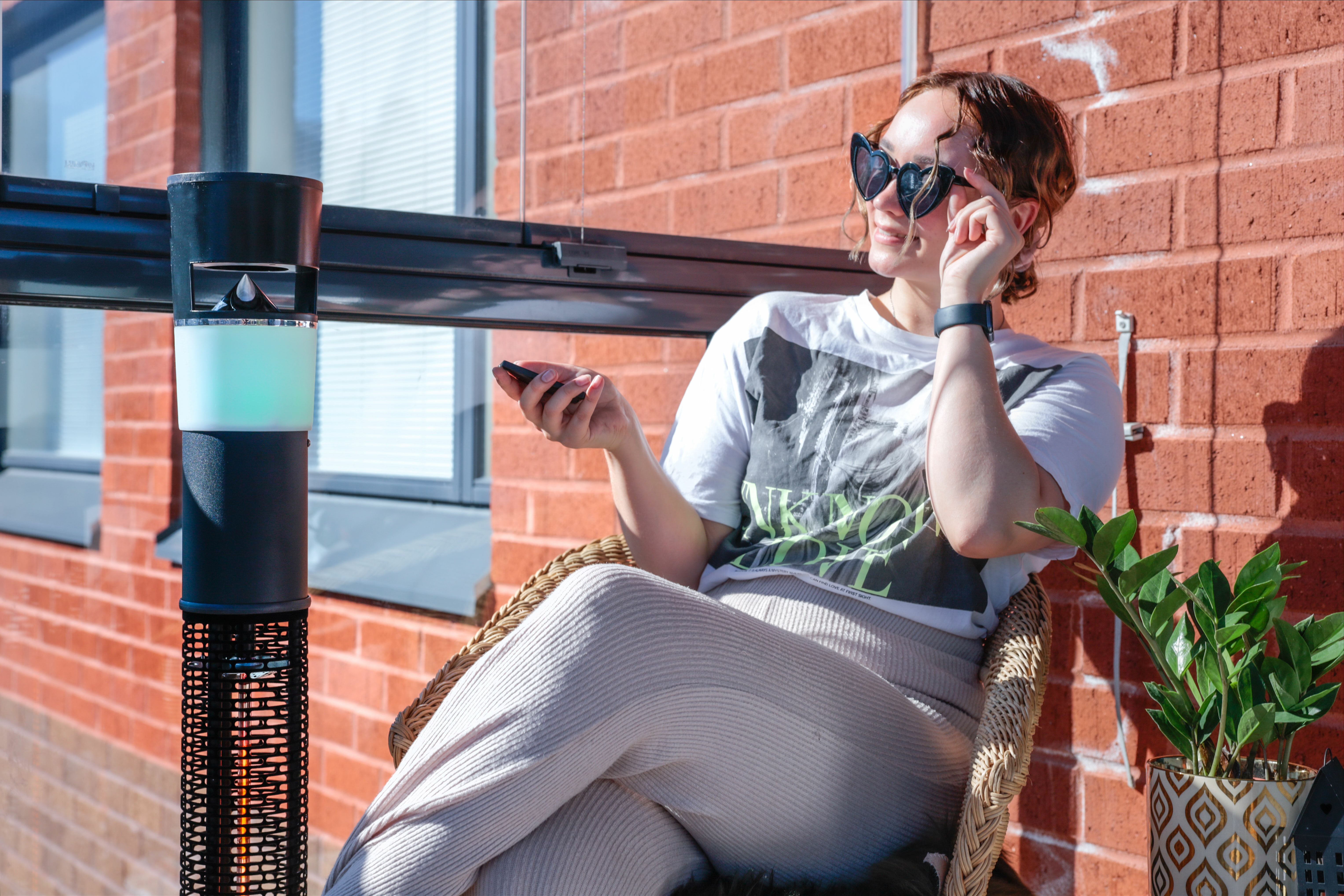 Woman adjusting next to a patio heater on a balcony