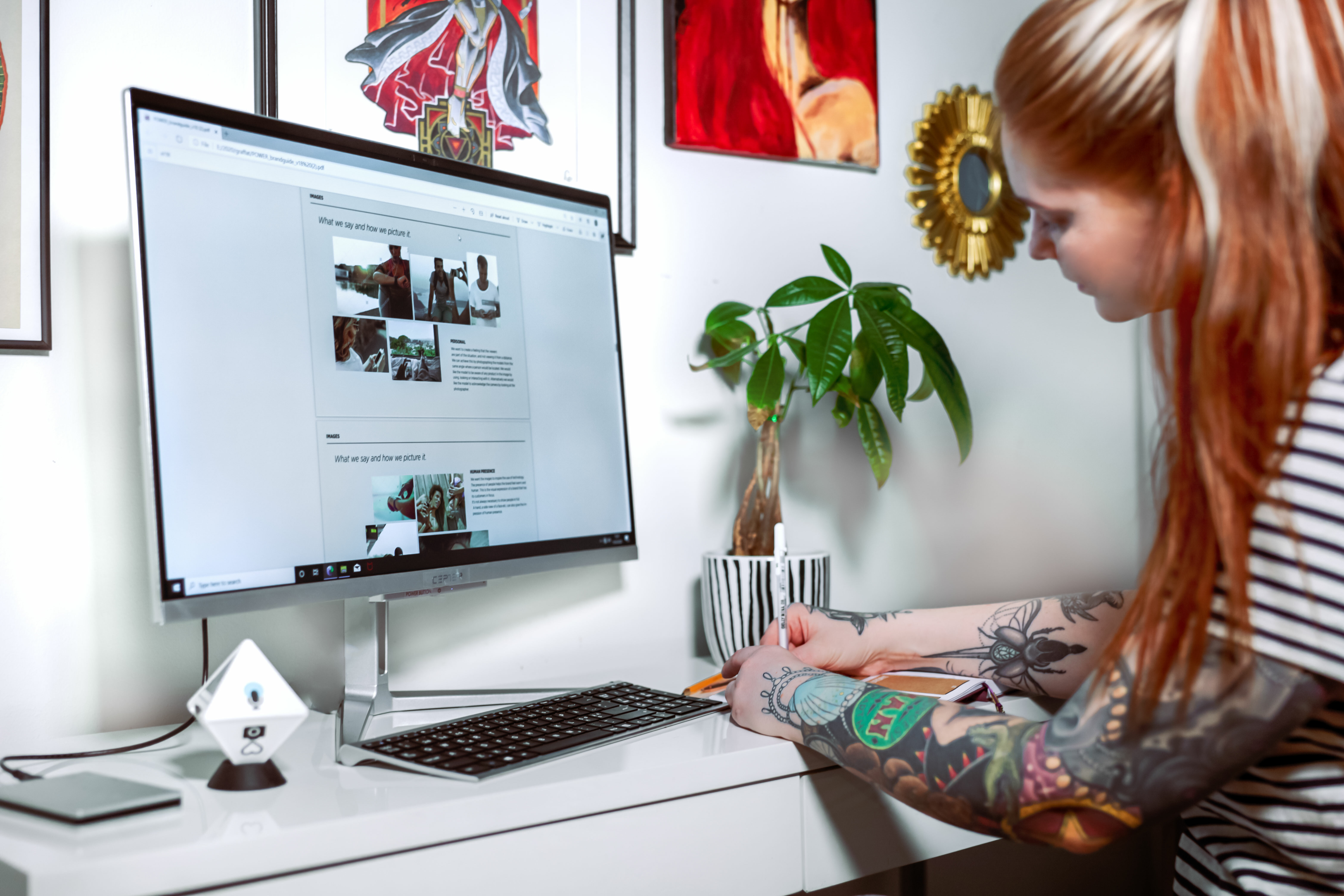 Woman making notes on a desk, next to Cepter Sense PC