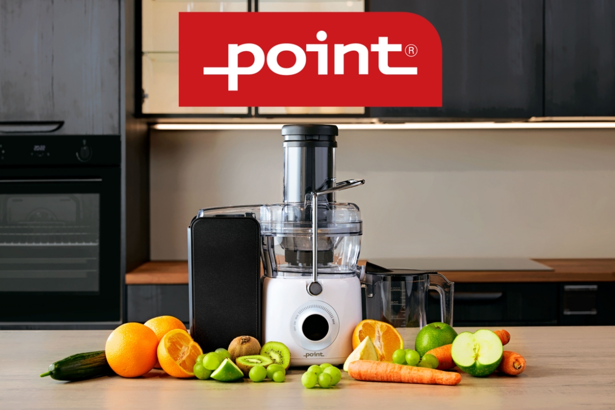 An image of a white Point juicer on a wooden kitchen table with green and orange fruits surrounding it and a Point logo above the device