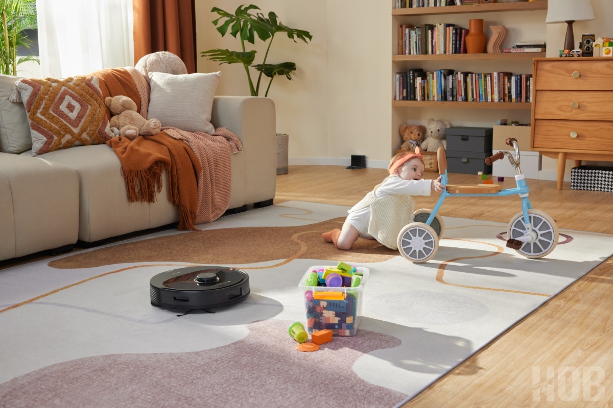 ROBOROCK Q8 MAX ROBOT VACUUM BLACK vacuums a grey carpet as a toddler plays next to it