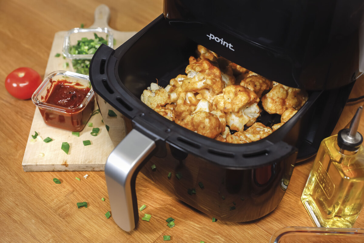 close up of the inside of the airfryer and cauliflower inside