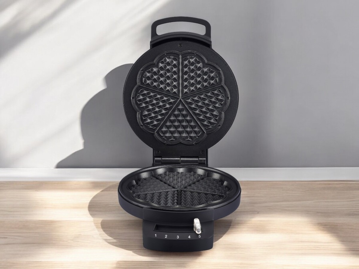 General wide angle image of POINT POWM5000S WAFFLE MAKER SINGLE open, on light wooden countertop with shadows cast around it