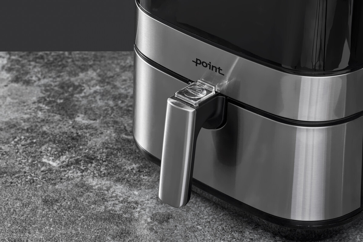 Close up of the airfryer on the grey surfase and black back ground