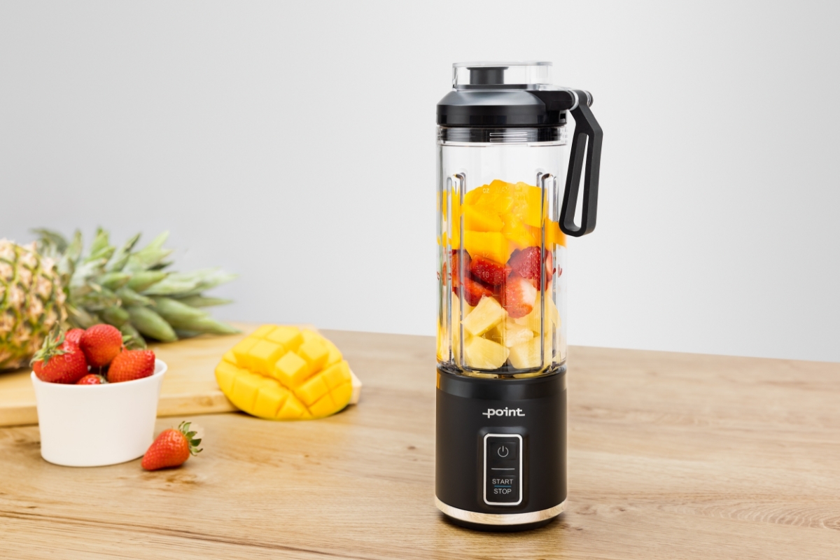 POINT POSB5000 RECHARGABLE SPORT BLENDER A black Point rechargeable travel blender on a wooden table filled with yellow, orange and red berries and some also behind the blender on the table in nice containers