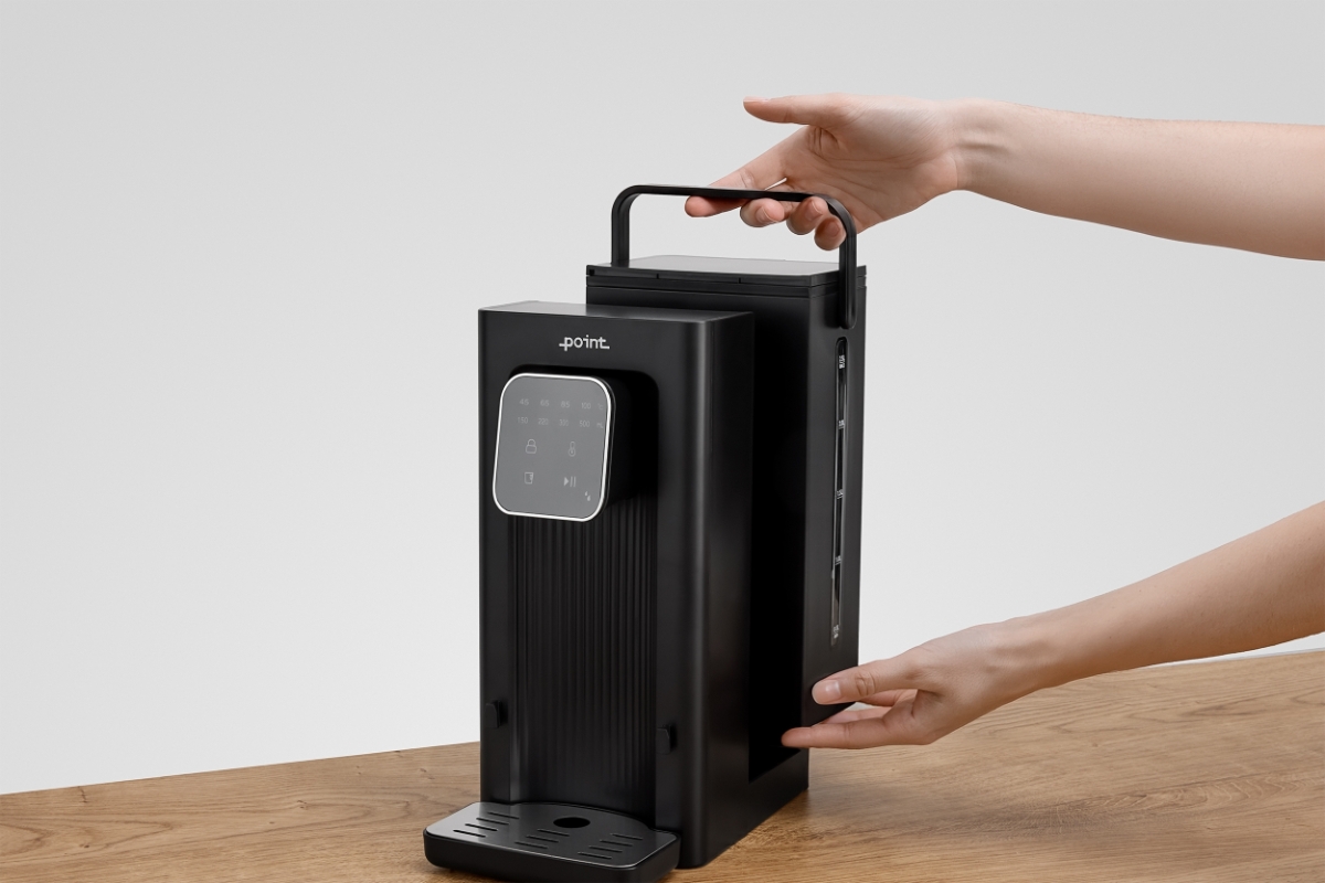 POINT POWD5000 INSTANT HOT WATER DISPENS The removable water tank of the black Point hot water dispenser being pulled off from the machine by two hands