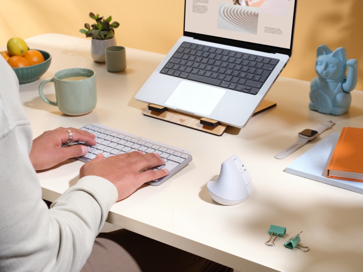 Person working on a computer desk, using Logitech Lift vertical mouse