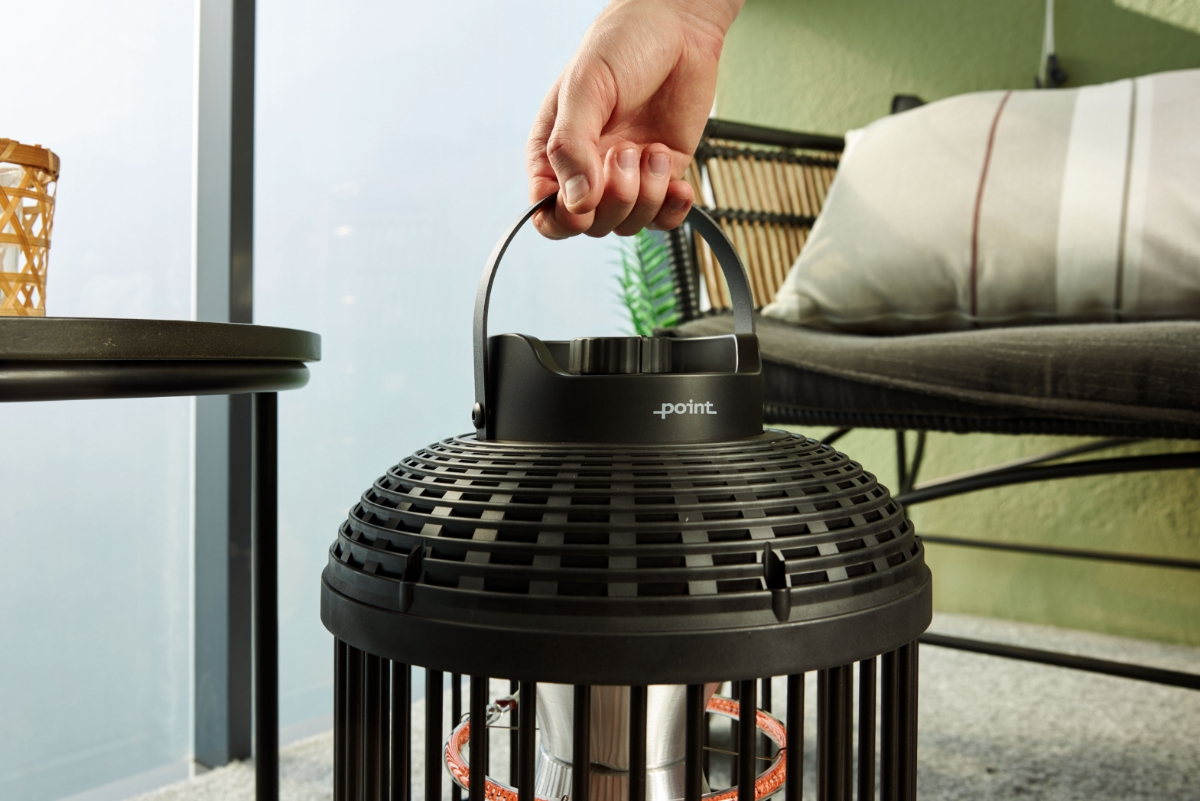 A wide shot of a person's hand lifting the POINT PRO POPHLAN47 patio heater up from its handle