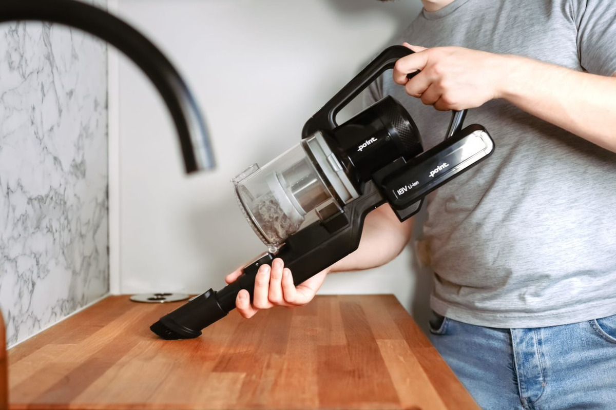 Close up of the handheld vacuum cleaner of the POINT POVC618DB 18V stick vacuum cleaning wooden kitchen countertop