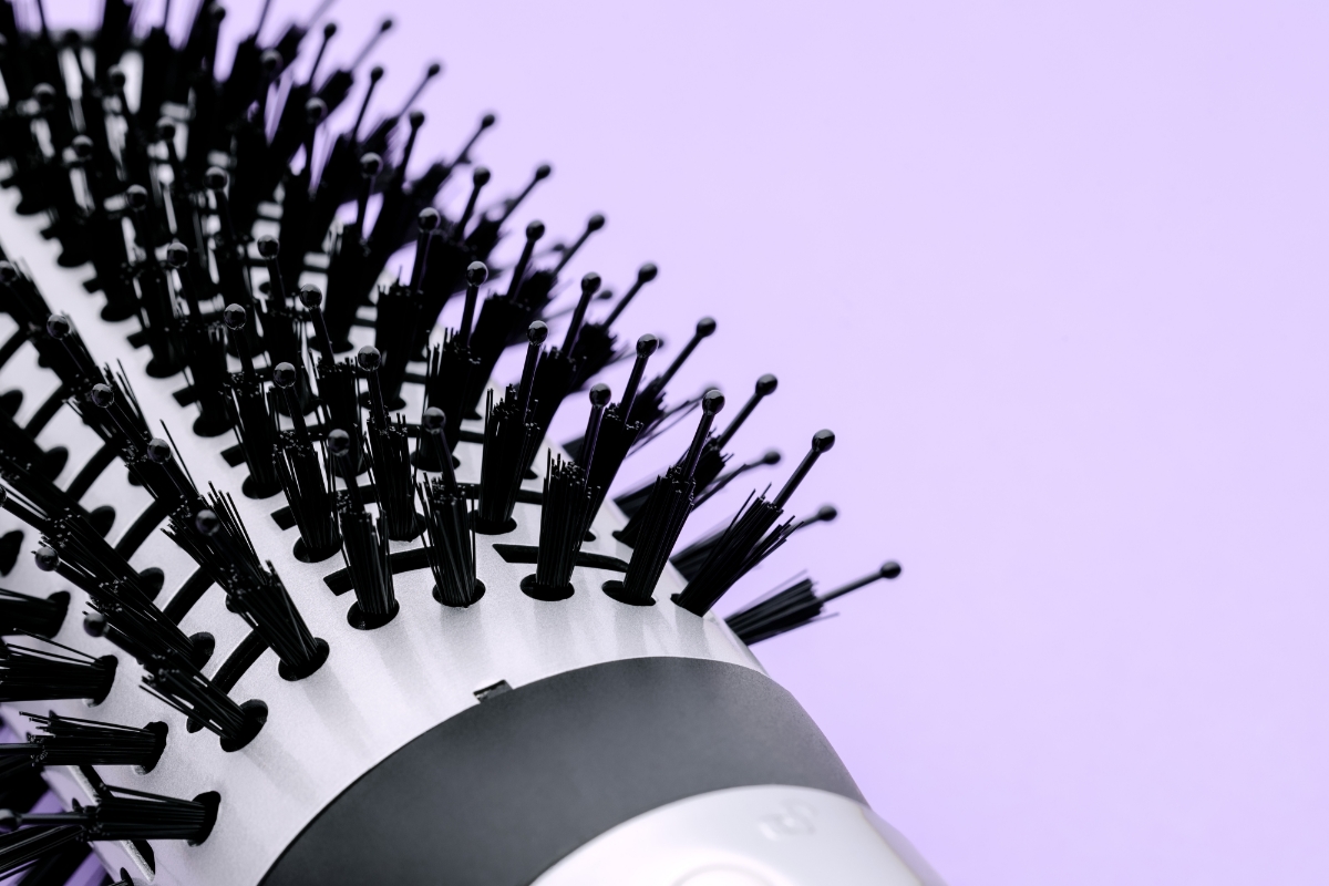 A close-up picture of a Point hot air brush's black bristles with a purple background
