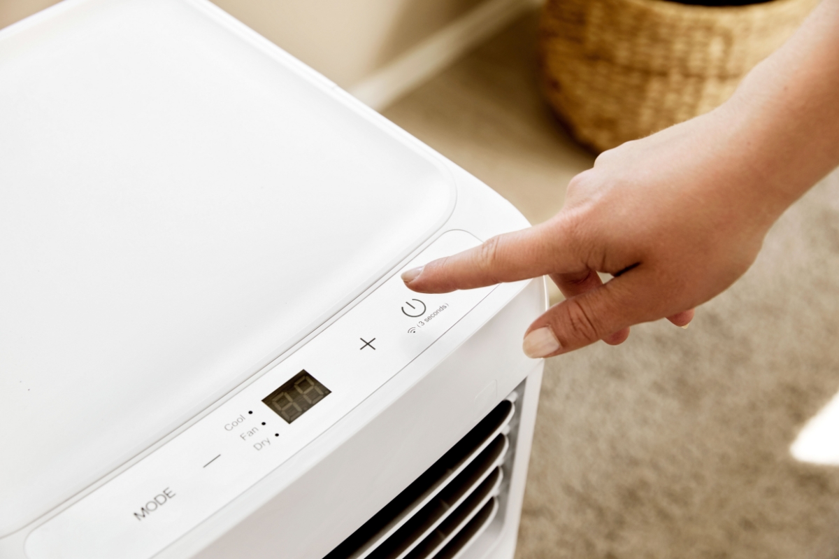 Close up of person pressing the buttons of the LED display of the Point POAC7024 air conditioner
