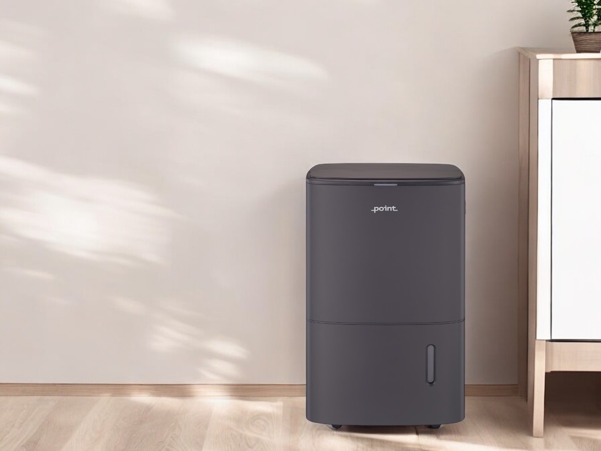 POINT PODHAP20G DEHUMIDIFIER/AIR PURIFIER against a beige wall, with a white dresser showing on the right side