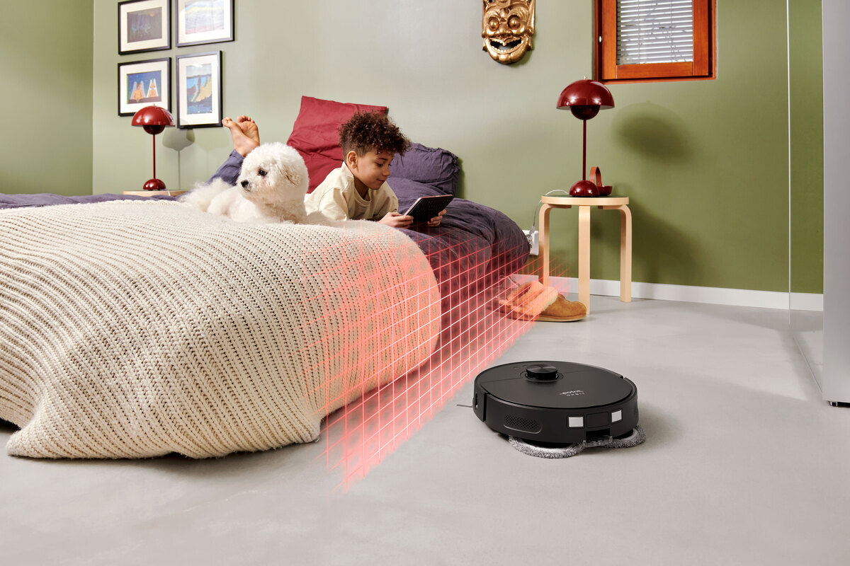 Robot vacuum scanning the bed in the kids room, kid and dog laying and playing on the bed