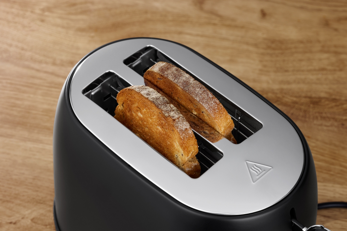Clsoe up of the two toasting slots of POINT POT5020BK RETRO TOASTER BK/2 SLOTS, filled with toasted bread