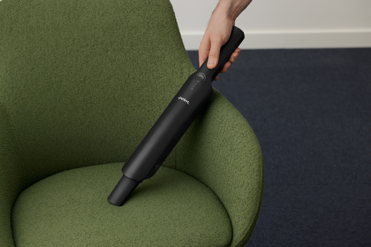 Close up of POINT CRAYON HANDHELD VACUUM CLEANER BK vacuuming a green upholstered chair