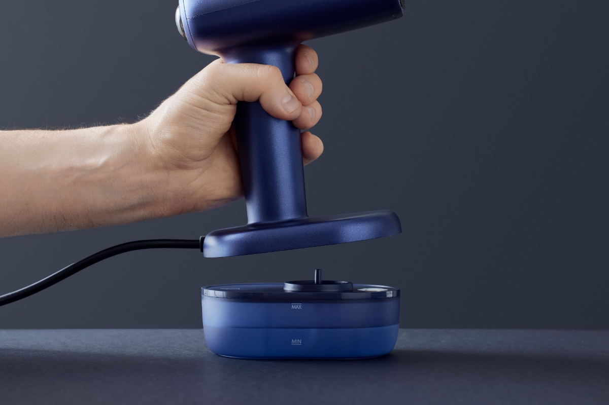 Close up of a person detaching the POINT PRO POHS15PRO STEAMER from its base and water container