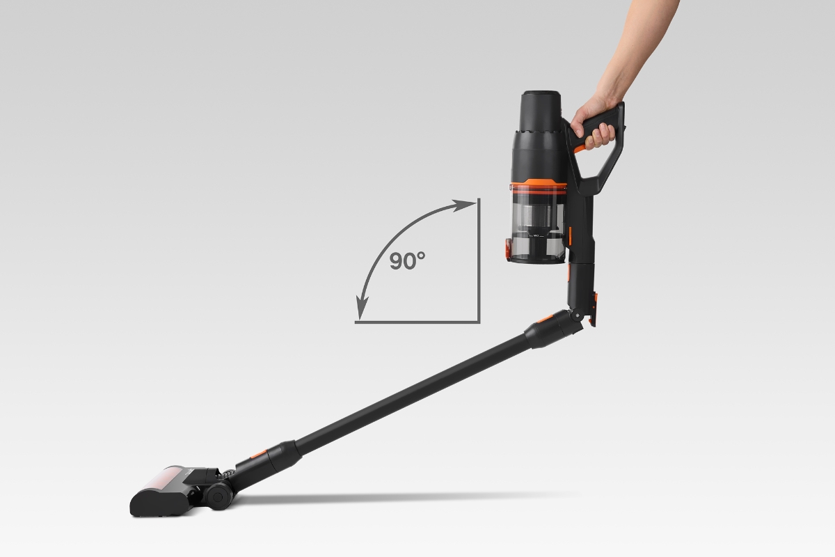 A black and red colored Point Cruise stick vacuum cleaner in a retracted position in a 90° degree with a person holding its handle and with an all-white background
