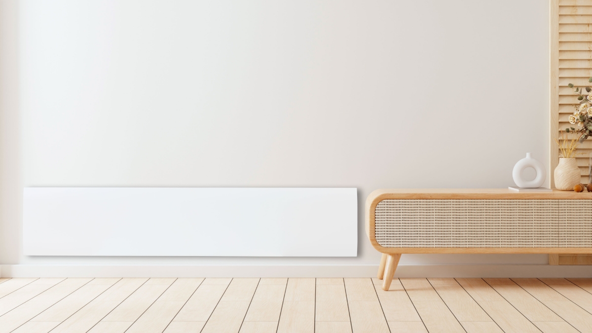 POINT POLISW1000 LOW PANEL HEATER, MATT WHITE on a white wall, with a beige tv console to the right of it