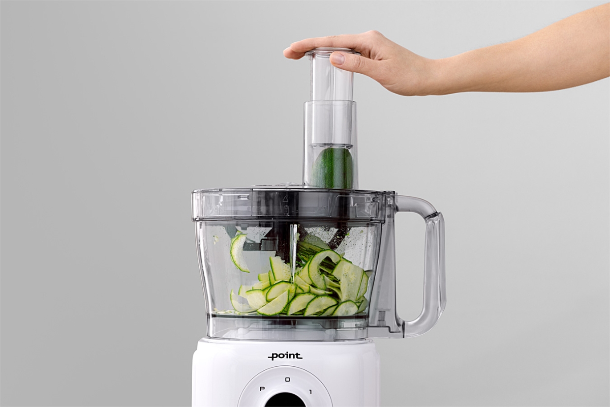 Wide angle image of a person shredding a zucchini with the POINT POFP5000 FOOD PROCESSOR 