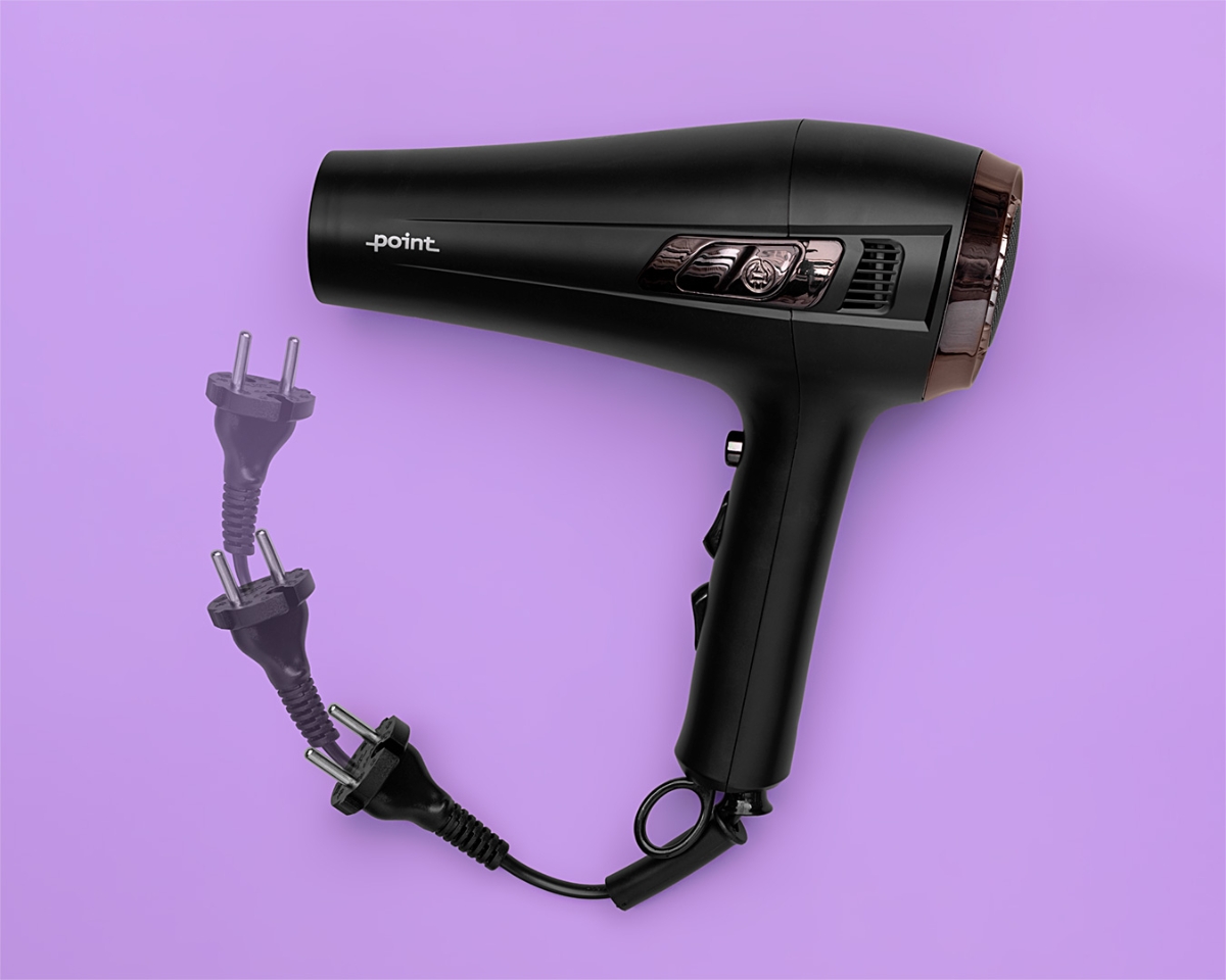 A black and rose-gold colored Point Retract hair dryer against a purple background with its retractable power cord moving inside the device